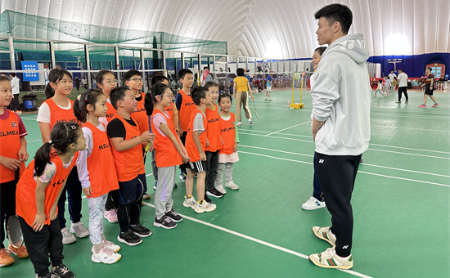 Badminton superstars coach children at Huanglong stadium